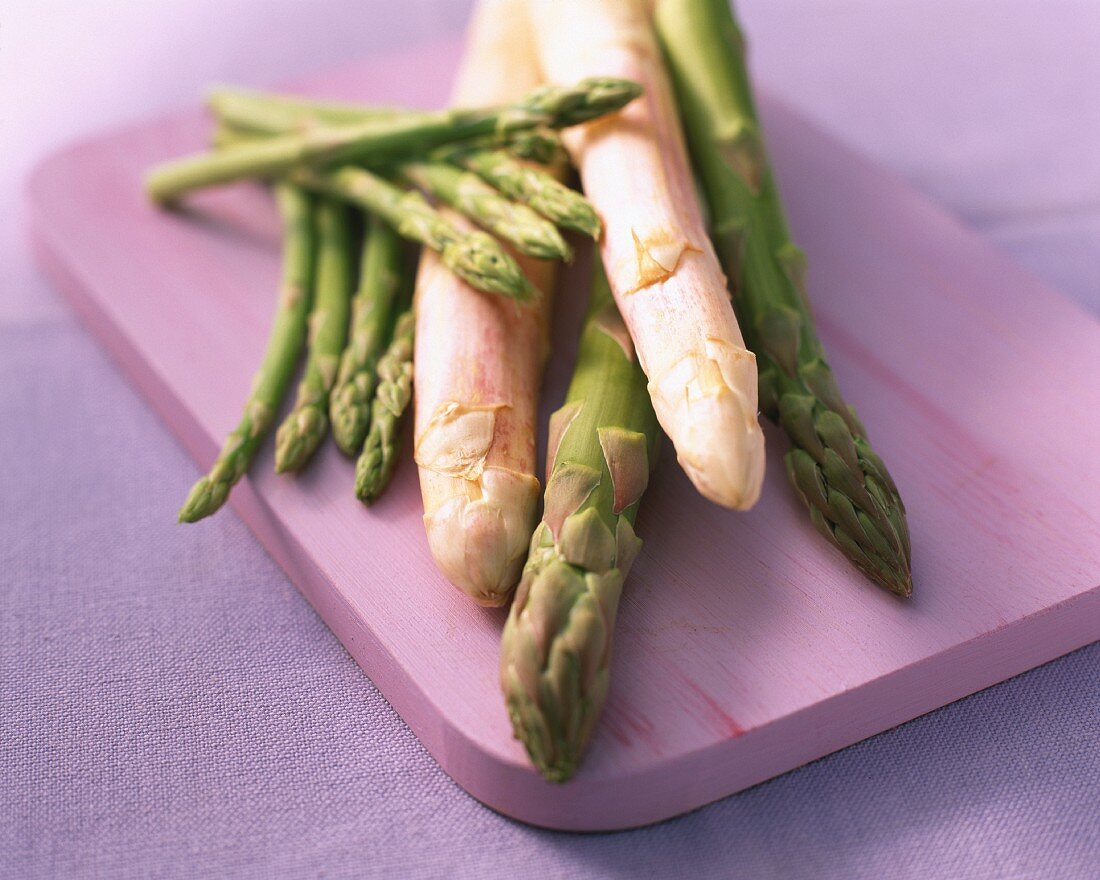 White, green and mini asparagus are chopping board