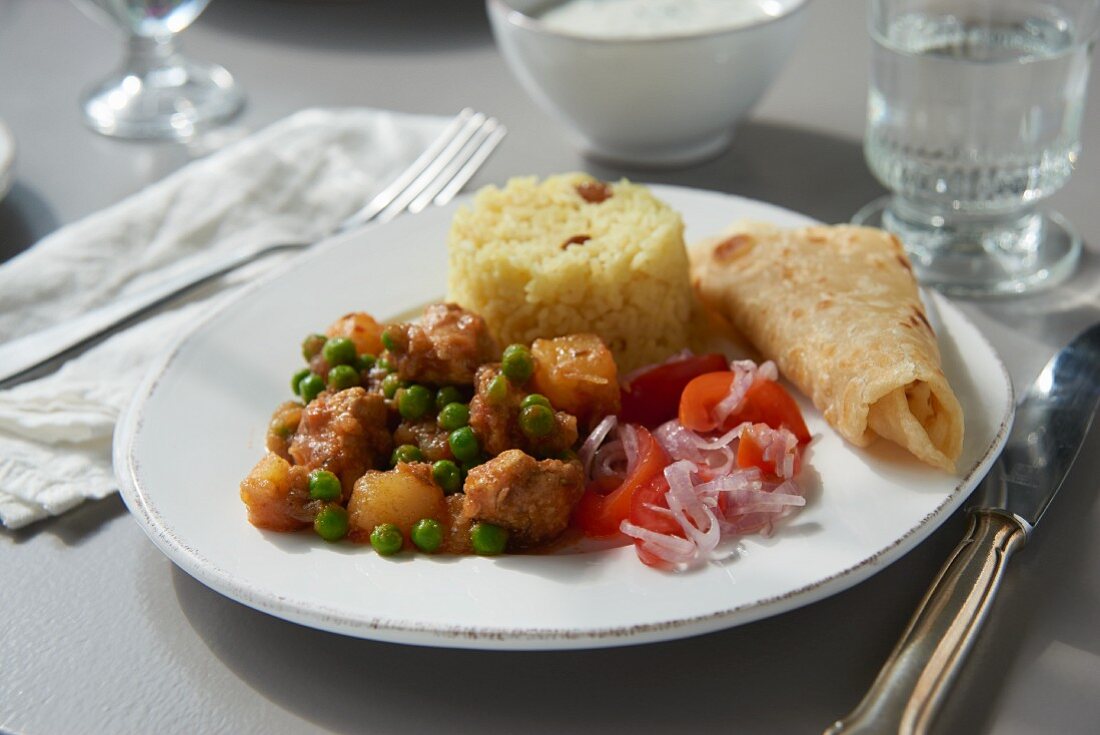 Hähnchencurry mit Erbsen, Tomatensalat und Reis (Südafrika)