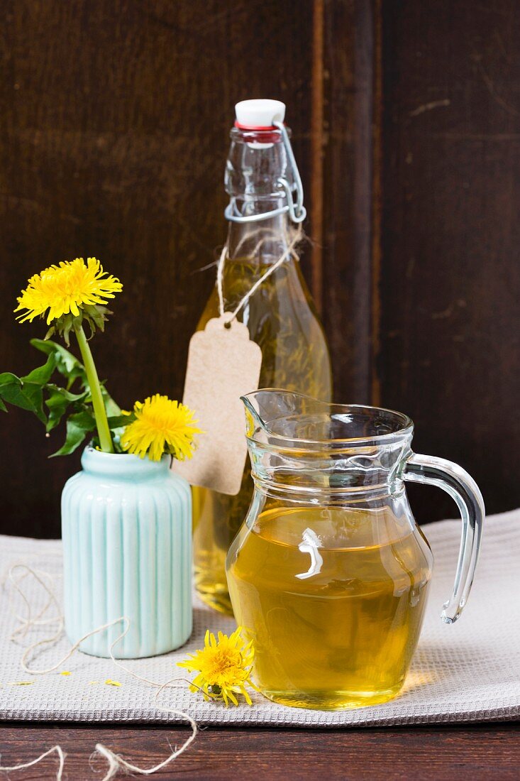 Dandelion syrup in a glass jug and a bottle