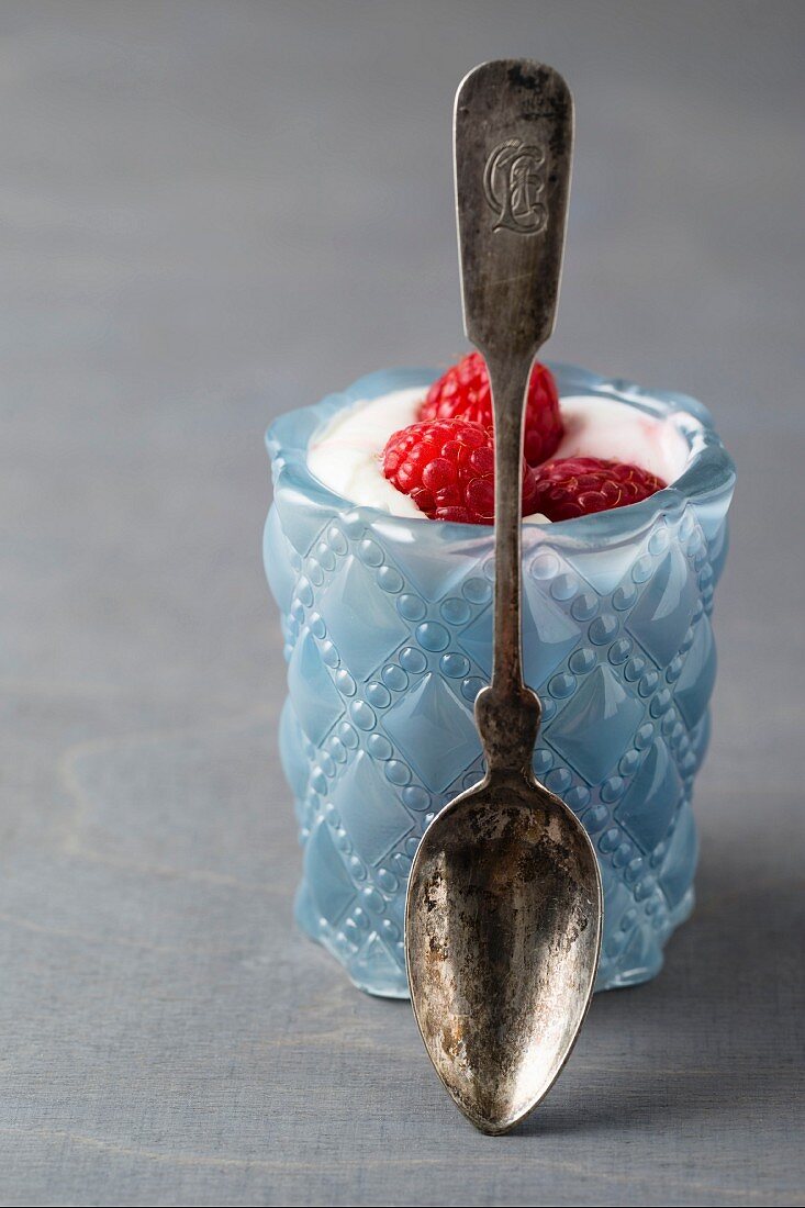 Joghurt mit Himbeeren im Glas mit Löffel