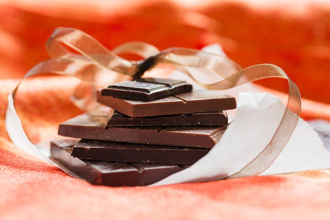 Schokoladenstücke gestapelt auf Einwickelpapier zum Verschenken