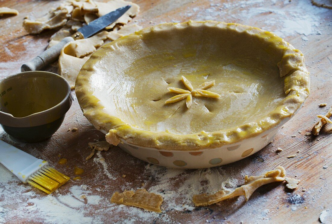 An apple and plum pie being made