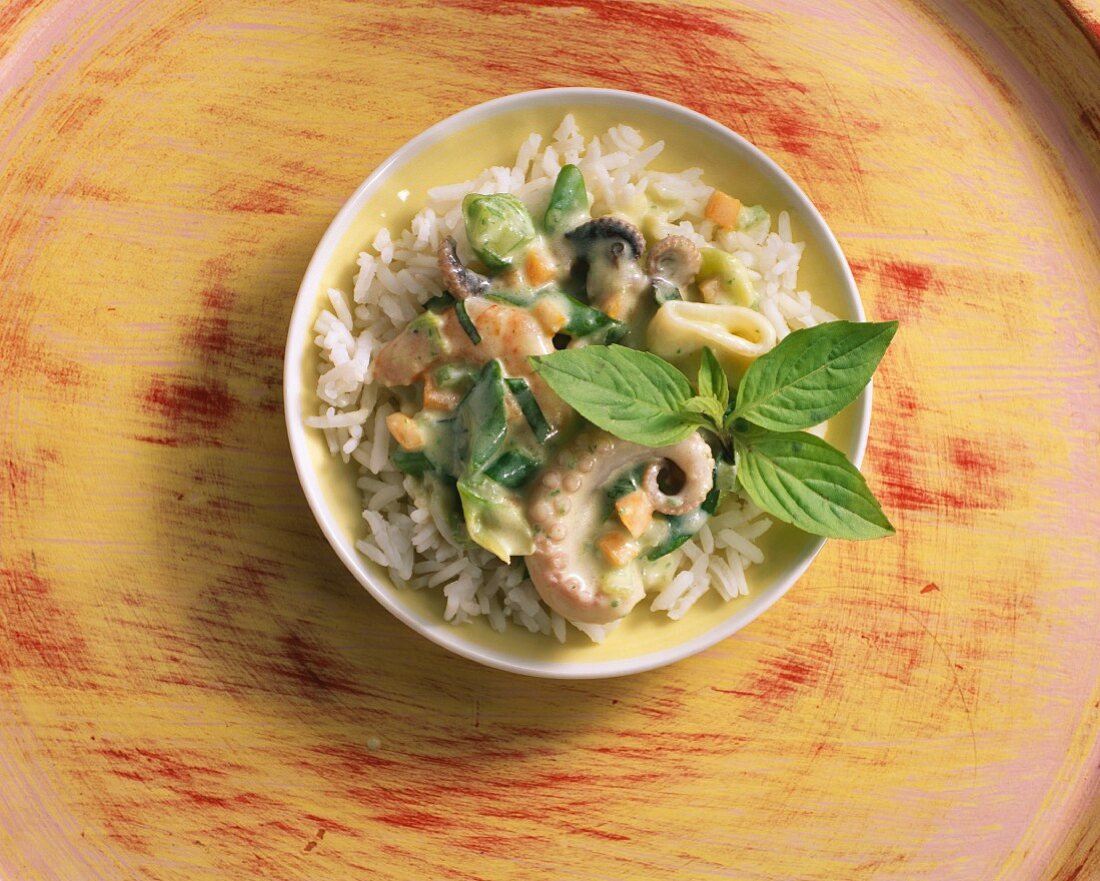 Meeresfrüchte in Kokosmilch auf Reis mit Thaibasilikum