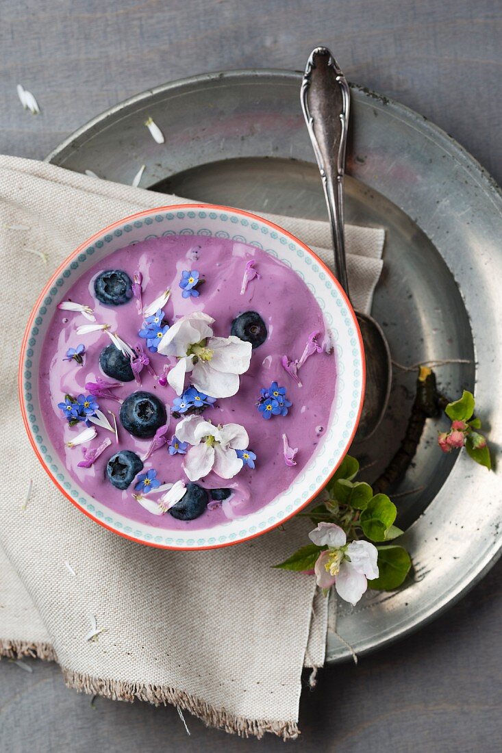Blueberry yoghurt with blueberries and edible flowers