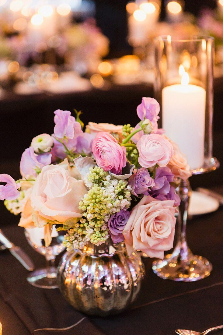 Candlestick & silver vase of roses as wedding table decoration