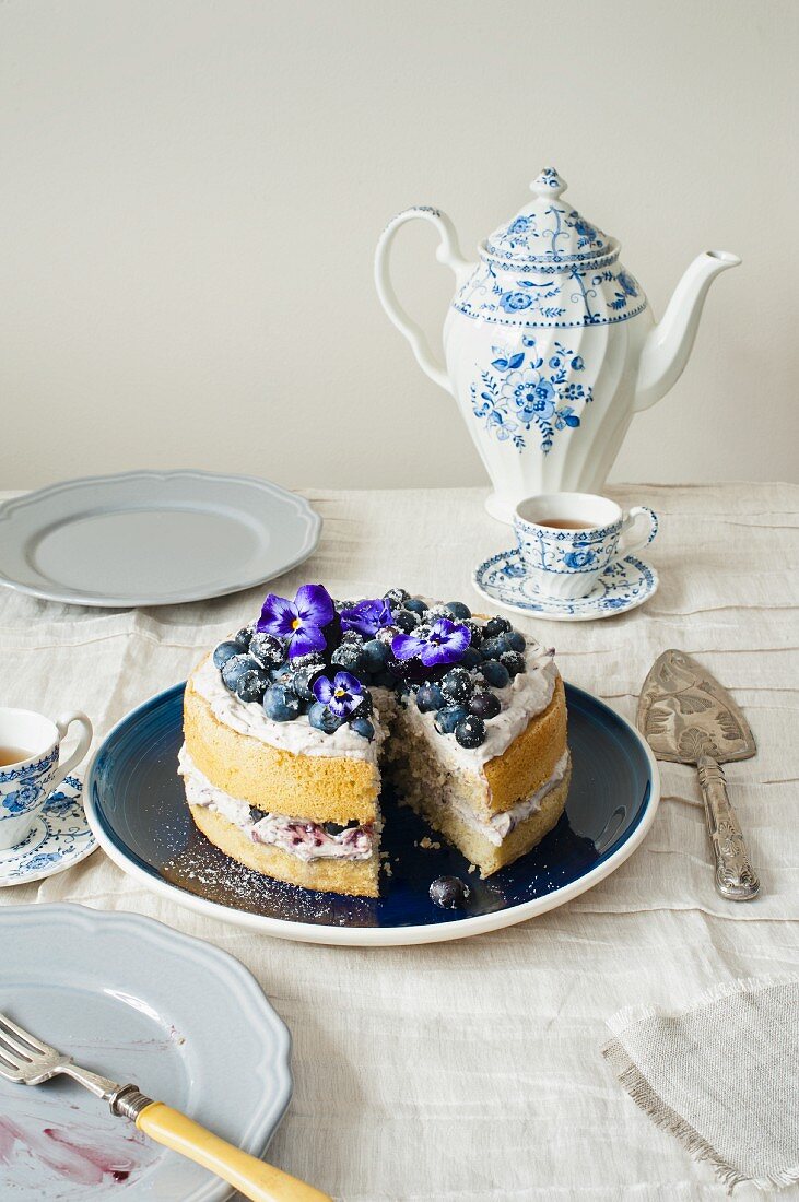 Blueberry cake with mascarpone and blueberry cream and pansies with vintage tee crockery