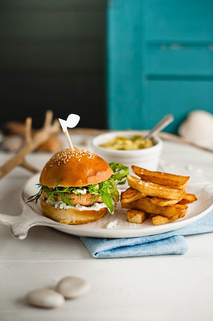 Lachsburger mit Dillmayonnaise, Rucola und Pommes frites, hausgemachte Guacamole mit Saubohnen