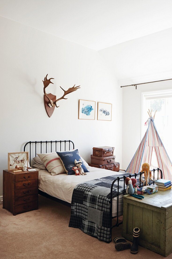 Country-house-style boy's room with black metal bed