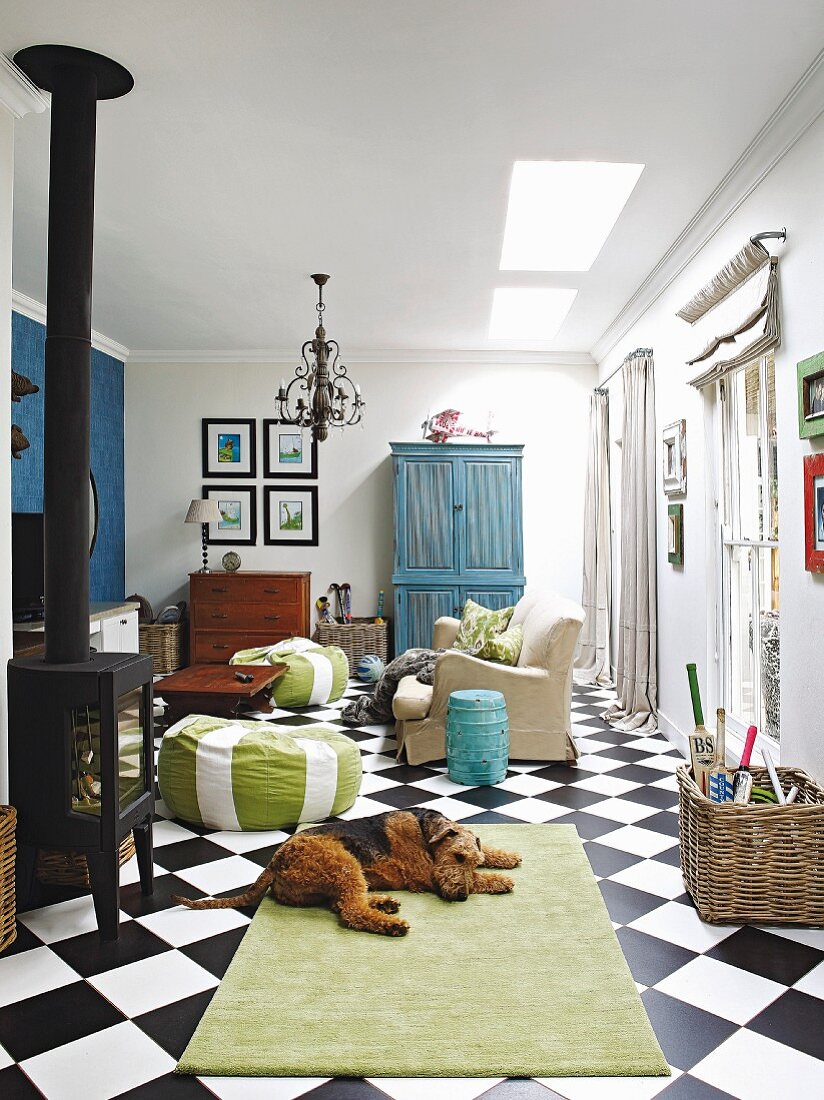 Wohnzimmer mit Kaminofen und Schachbrettboden, Hund auf Teppich