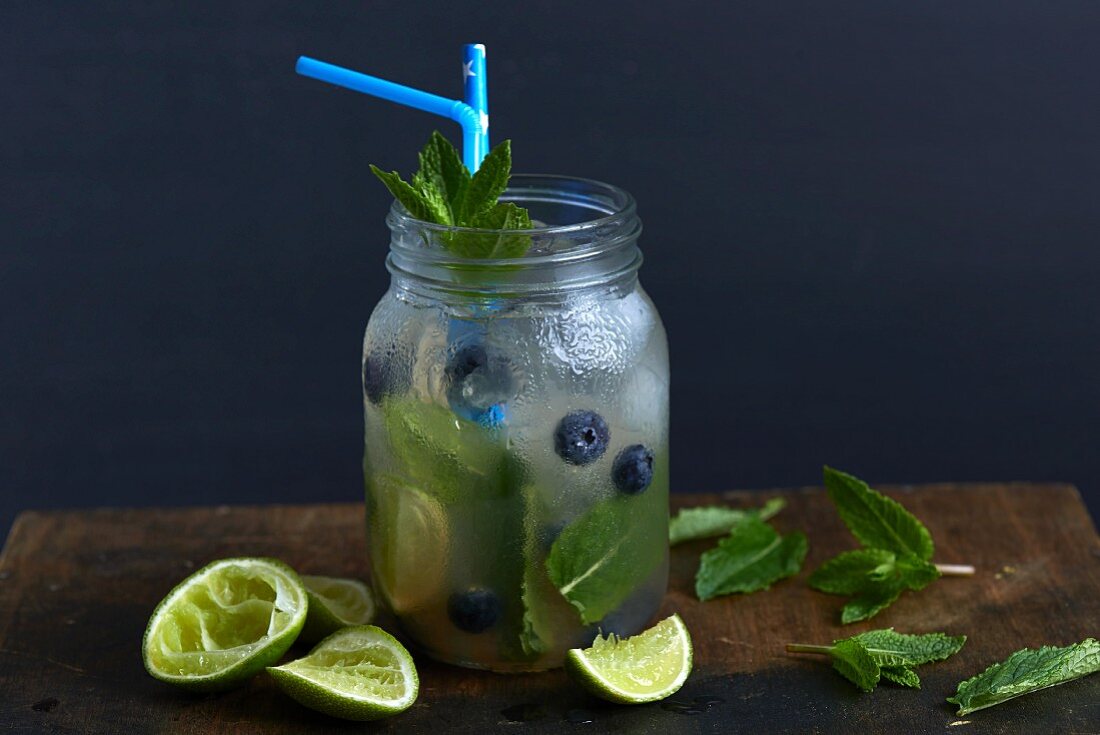 A mojito with blueberries and ice cubes