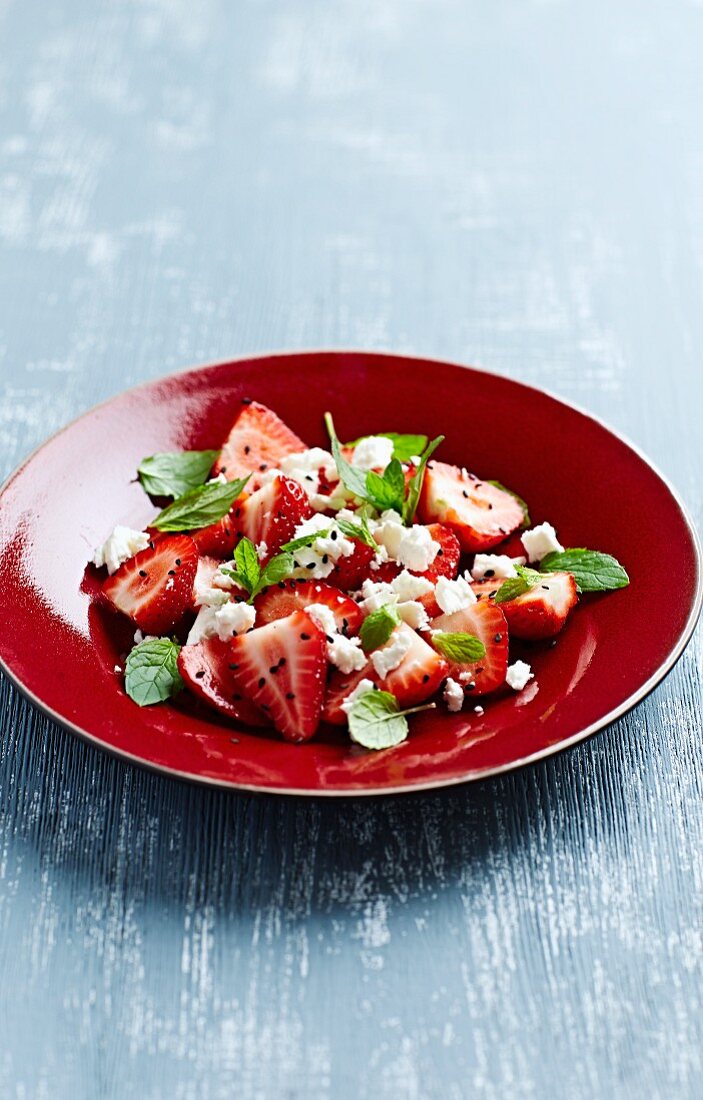 Strawberry salad with feta cheese, mint and black sesame seeds