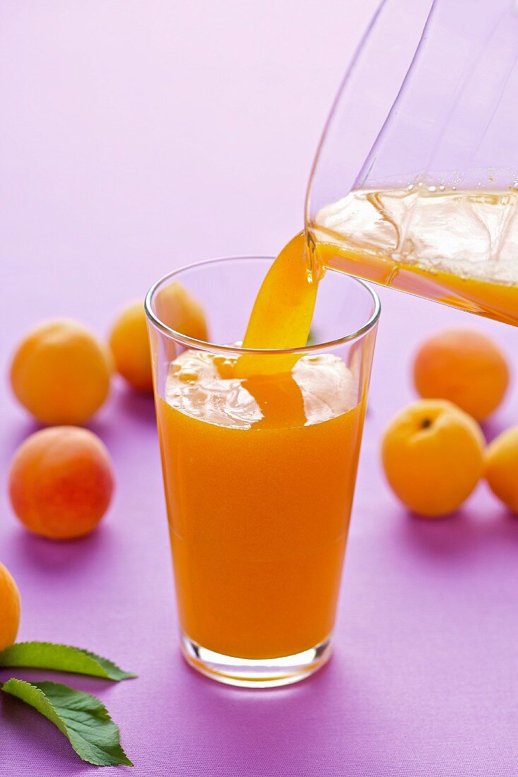 Aprikosensaft in ein Glas einschenken