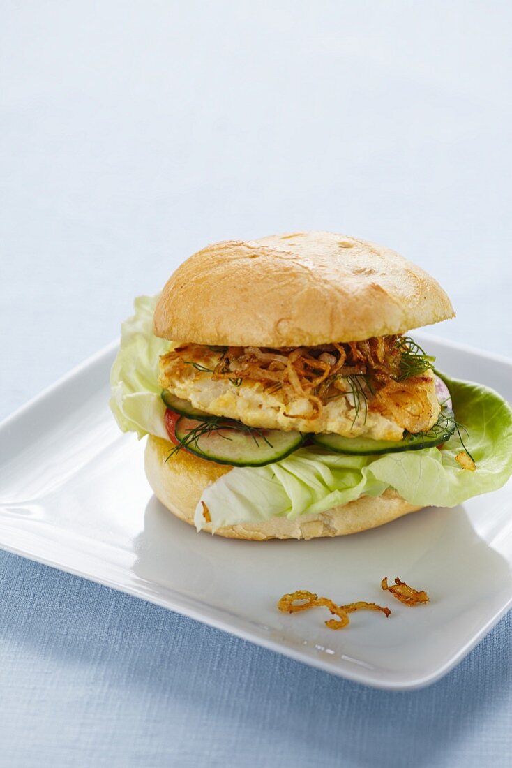 A hake burger with yoghurt and roasted onions
