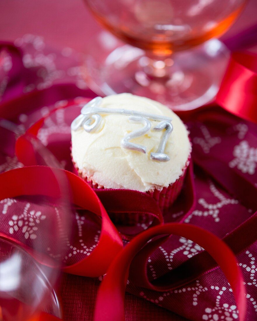 Geburtstags-Cupcake mit Vanille-Buttercreme, silbernem Schlüssel und silberner Zahl