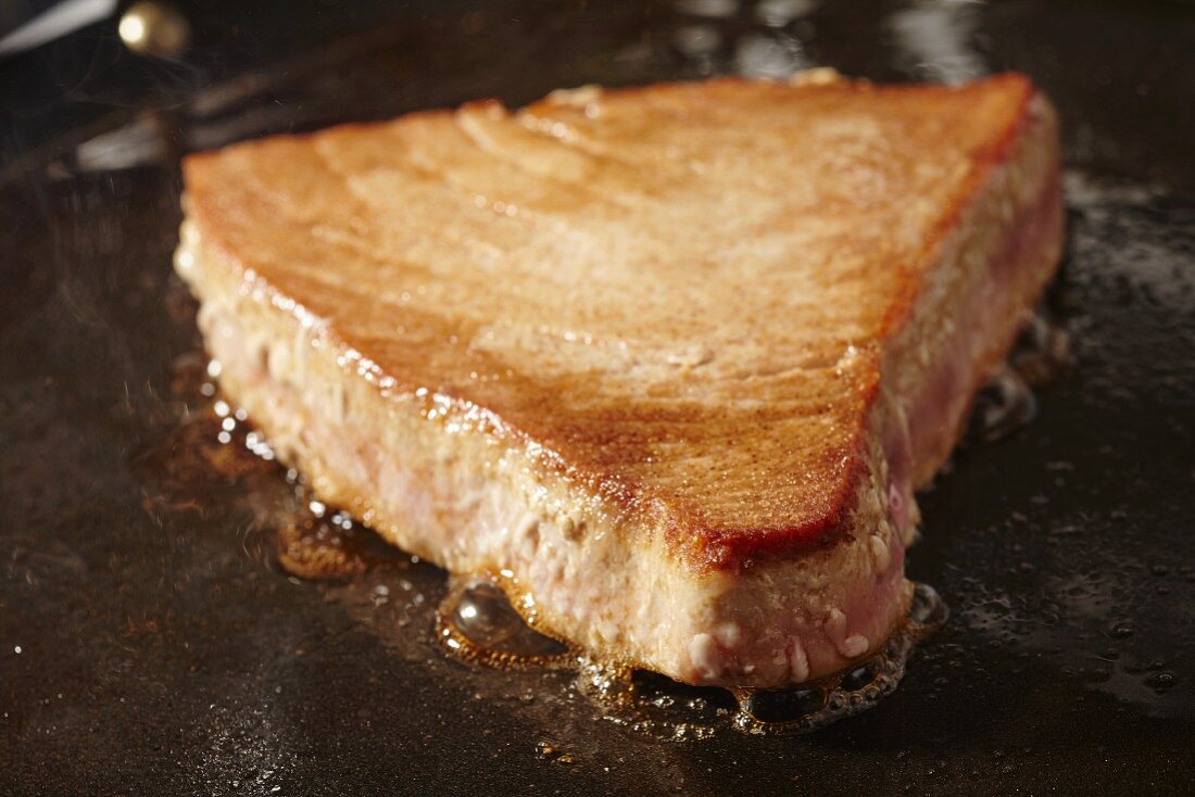 A tuna steak searing on a comal (a Latin American flat grill)