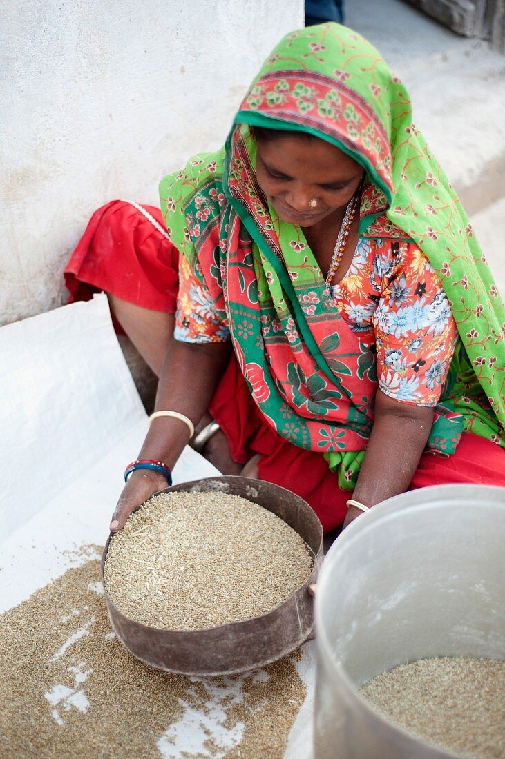Junge Frau beim Hirsesieben, Nirona, Kachchh, Gujarat, Indien