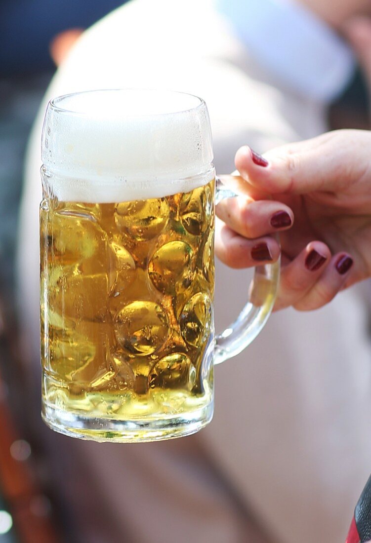 A woman holding a tankard of beer