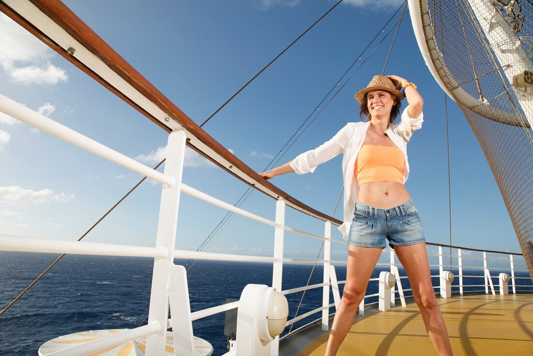 A brunette woman wearing summer clothing at the rail of a ship