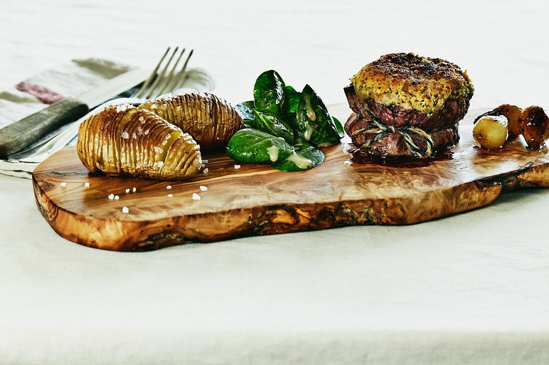 Beef fillet with a tarragon crust, Hasselback potatoes, baby spinach and glazed pearl onions