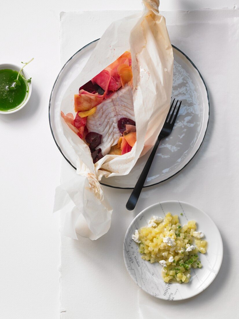 Cod fillet on root vegetables with horseradish oil in paper