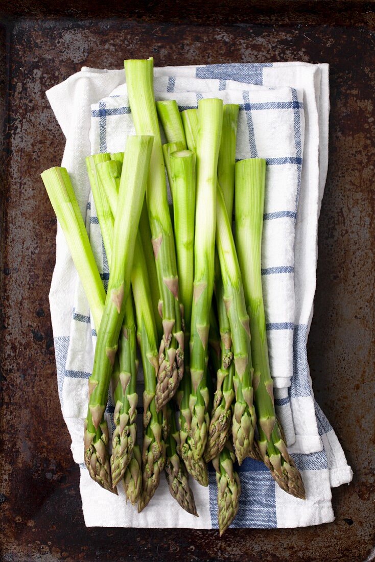 Peeled green asparagus on a tea towel