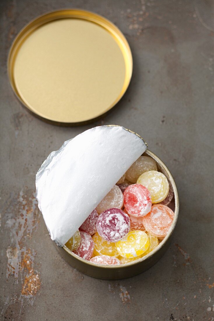 Fruit bonsbons with icing sugar in a tin
