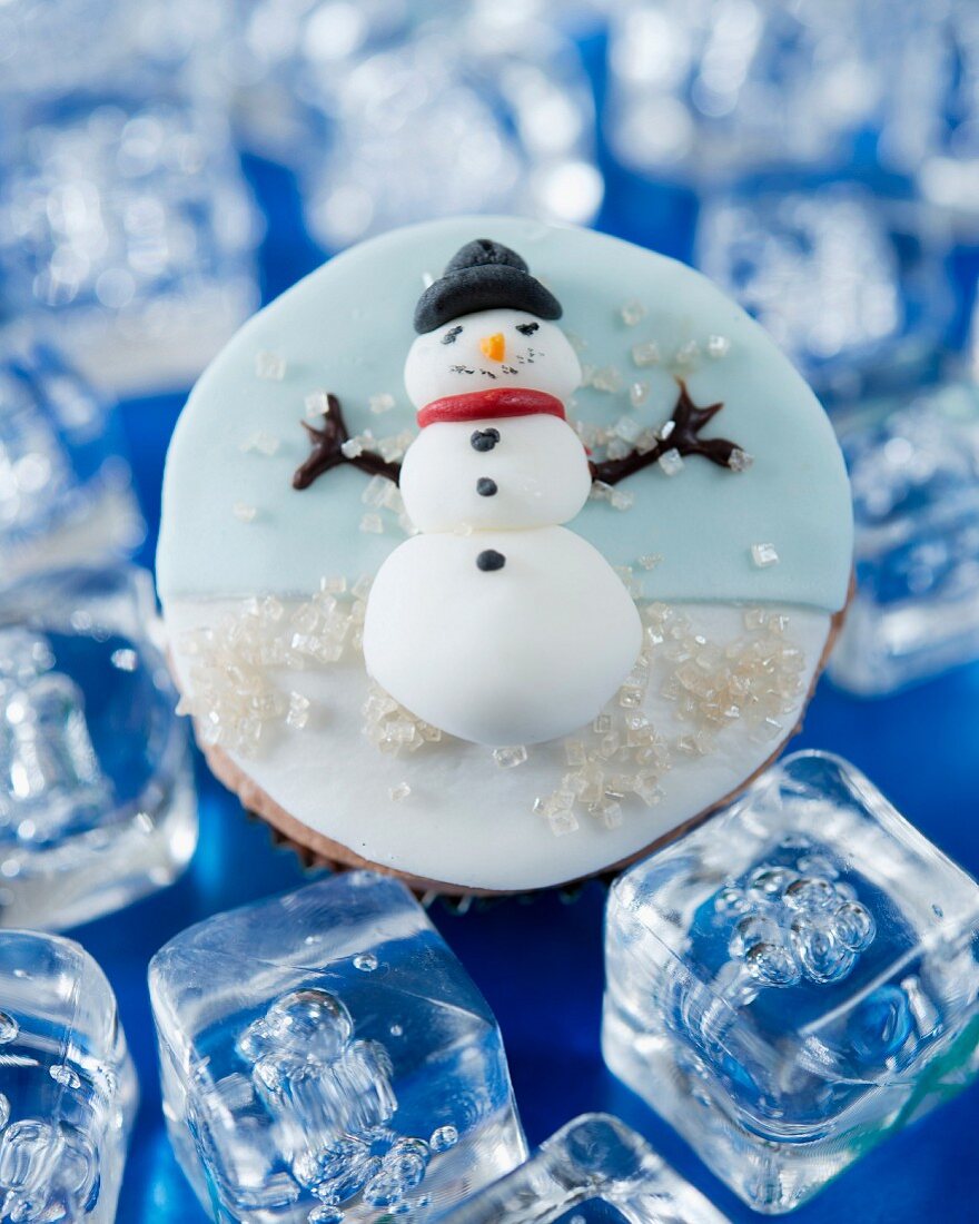 A cupcake decorated with a fondant snowman