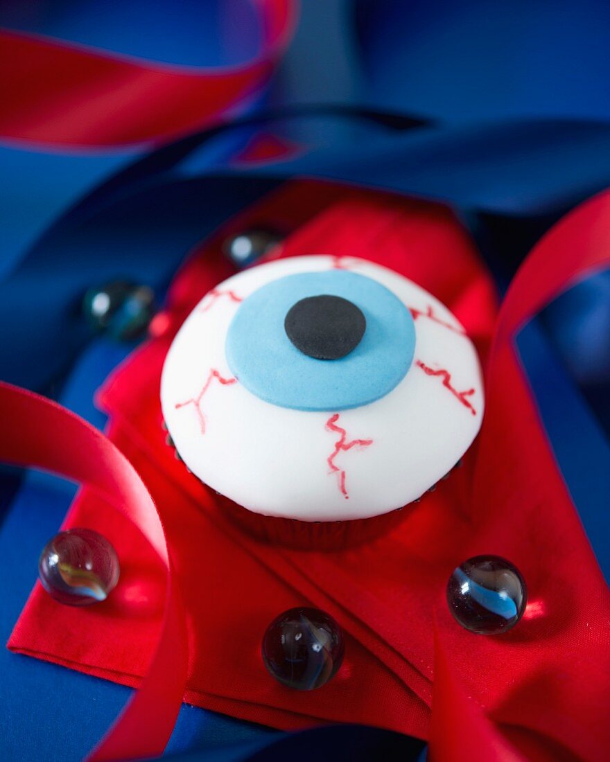 An eyeball cupcake decorated with fondant icing for Halloween
