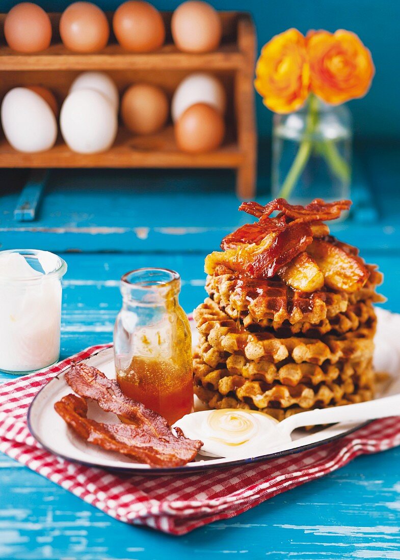 Almond and yoghurt waffles with bananas, orange syrup and crispy bacon