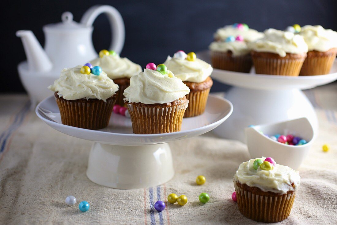 Karotten-Cupcakes mit Cremehaube & bunten Zuckerperlen verziert