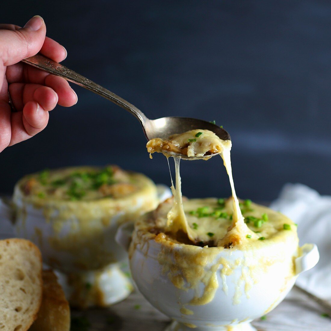 A person eating gratinated onion soup