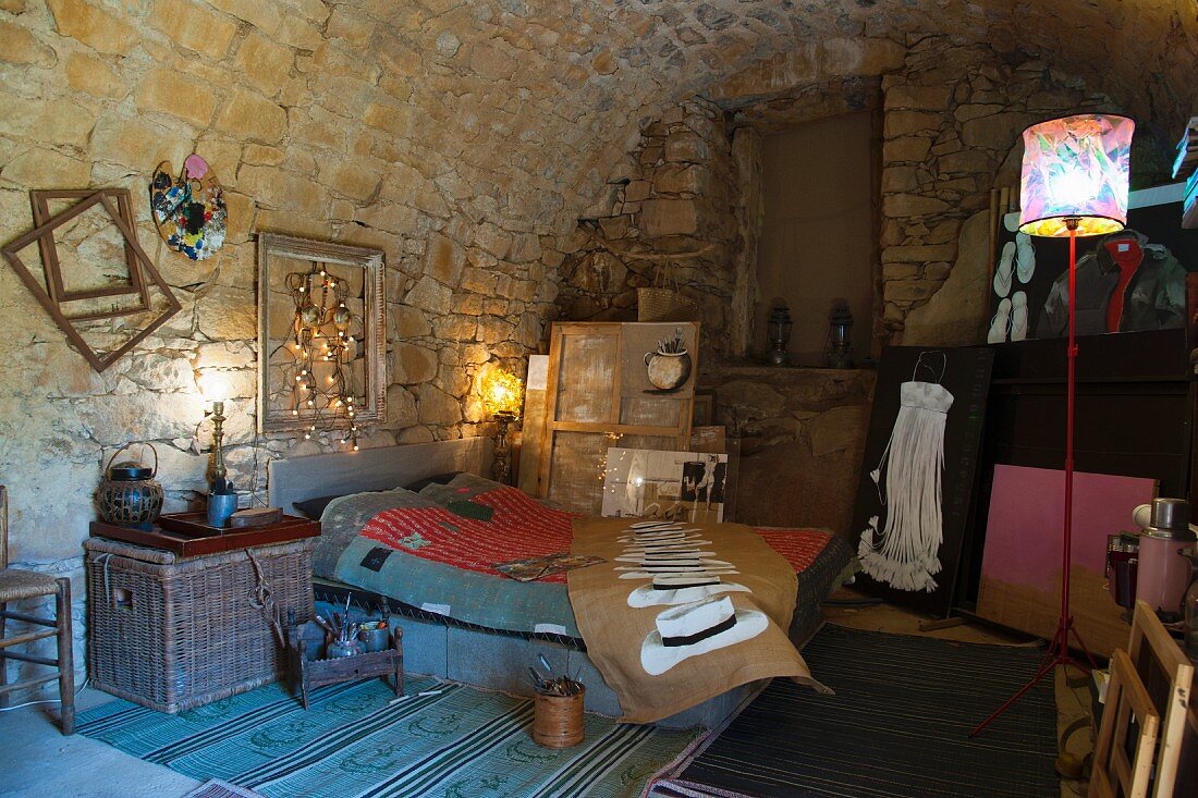 Artistically furnished bedroom under vaulted stone ceiling
