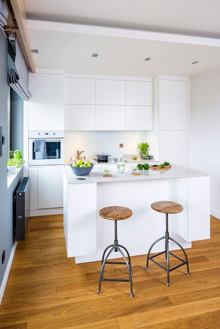 Open-plan kitchen with industrial-style bar stools at counter