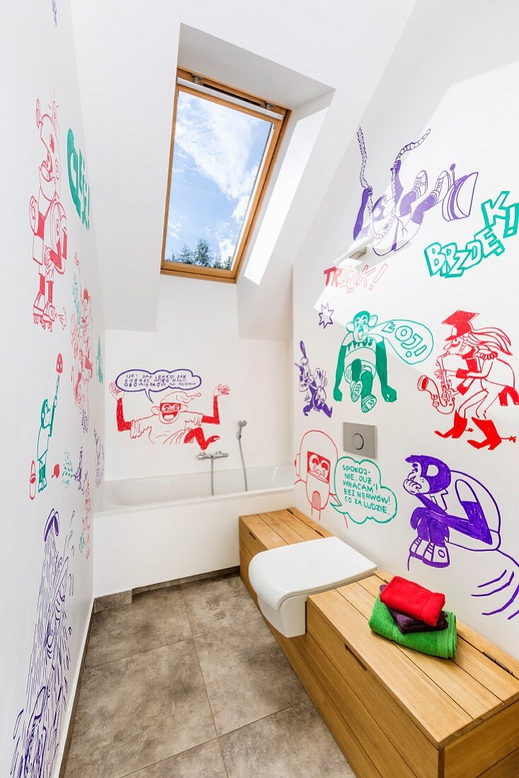 Modern attic bathroom with comic-style murals in various colours