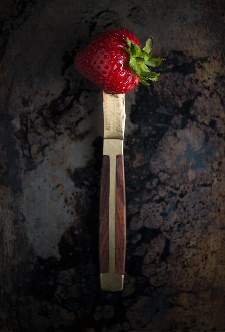A strawberry on a knife (seen from above)