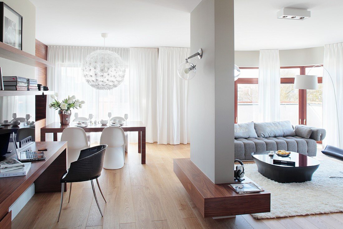 Dining area, seating area and home office against side wall in open-plan, modern interior