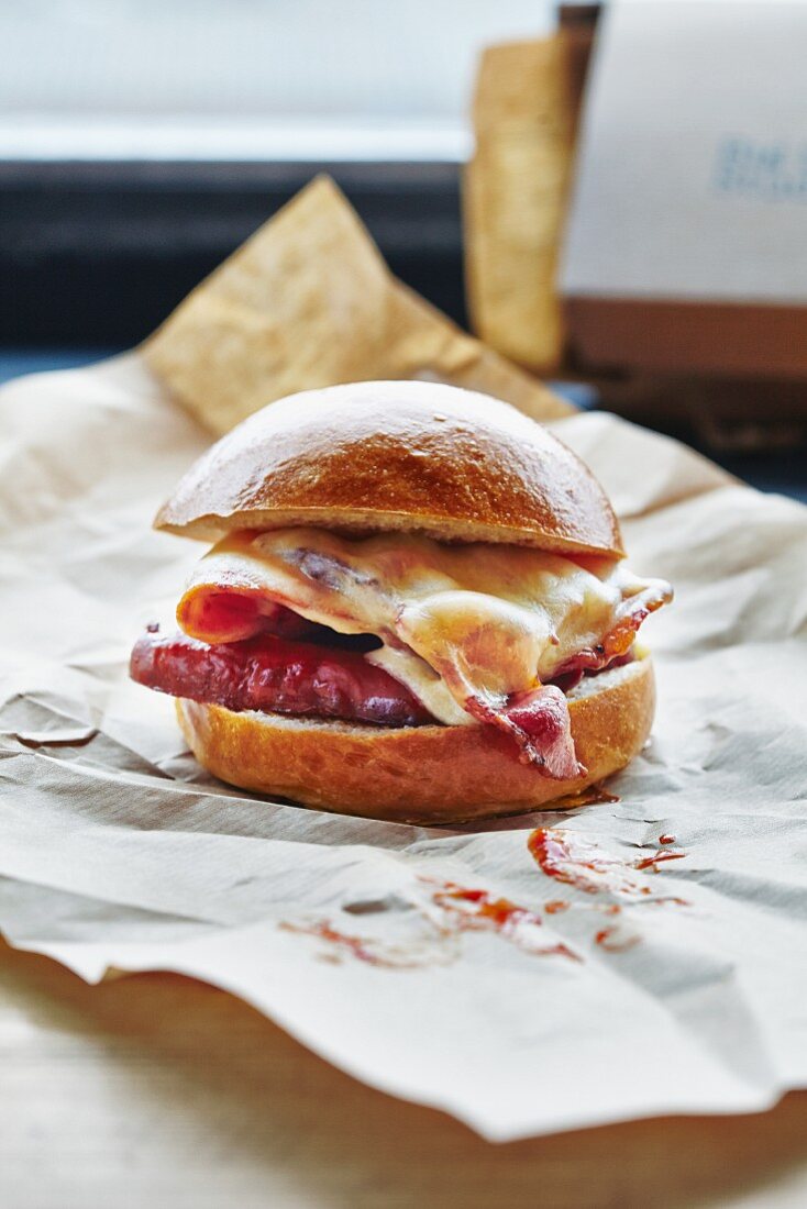 A bacon and cheese burger on a piece of paper