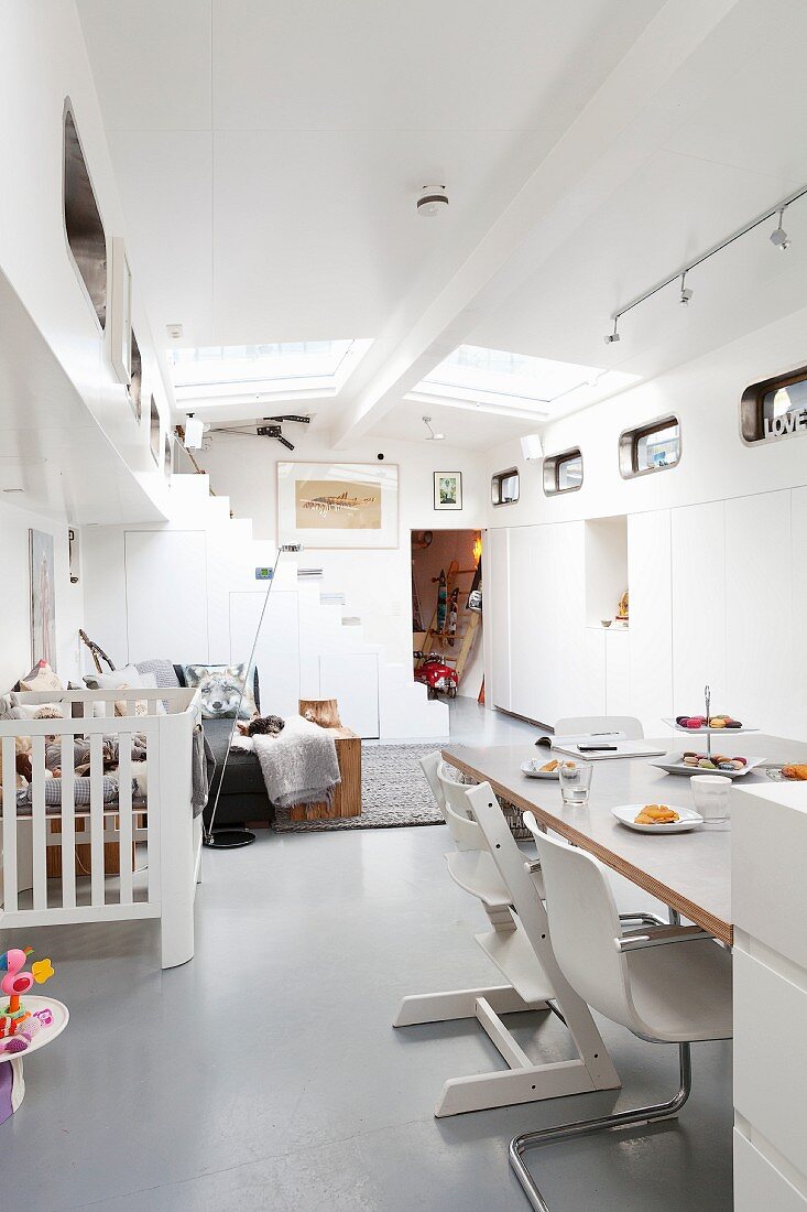 Cantilever chairs and Tripp Trapp highchair in open-plan interior of houseboat