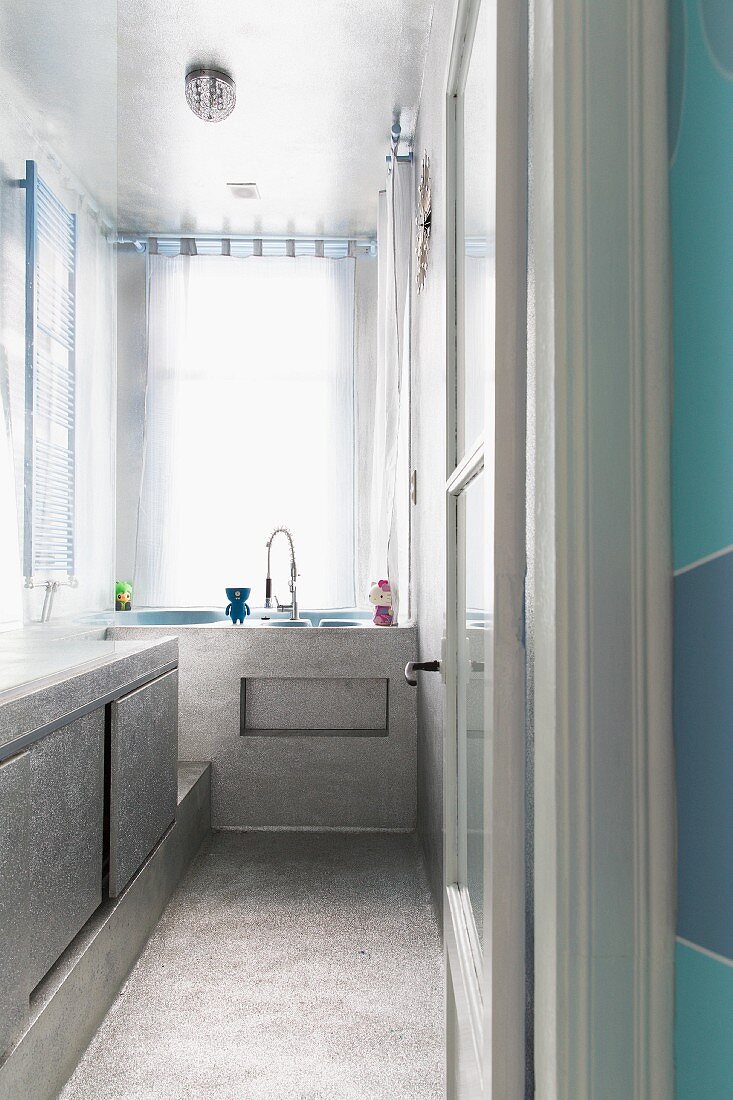 Shimmering silver surfaces in narrow bathroom