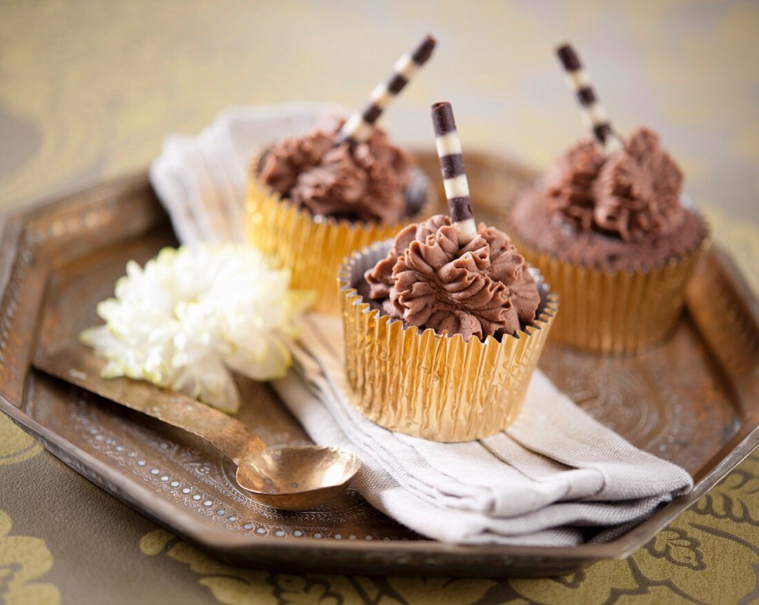 Schokoladencupcakes mit gestreiften Schokoladenröllchen