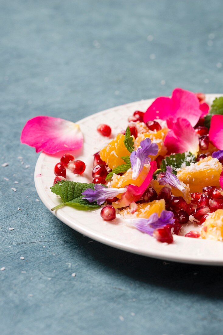 Orange and pomegranate salad with rose petals, sage flowers, lemon balm and grated coconut