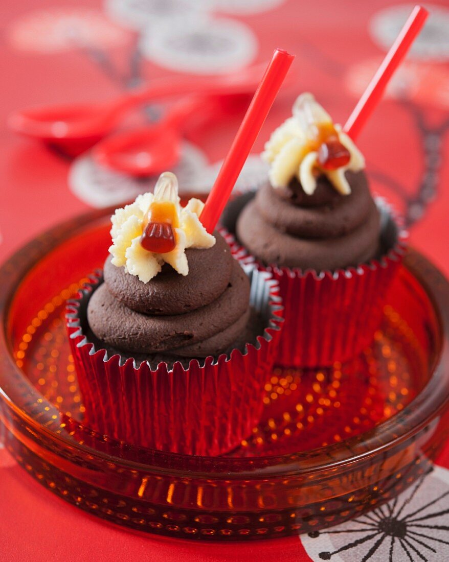 Schokoladen-Cupcakes mit Cola und Colafläschchen