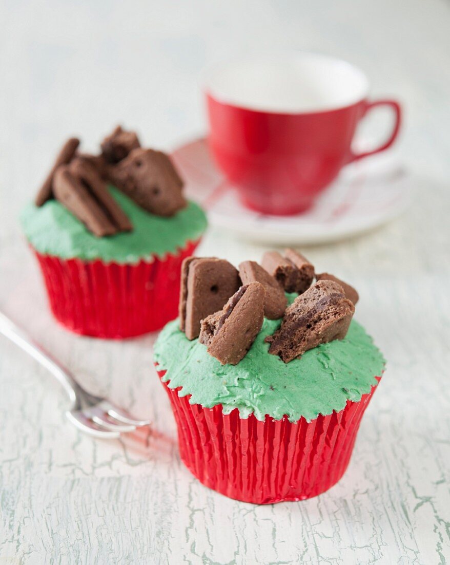 Chocolate cupcakes decorated with mint cream and chocolate biscuits