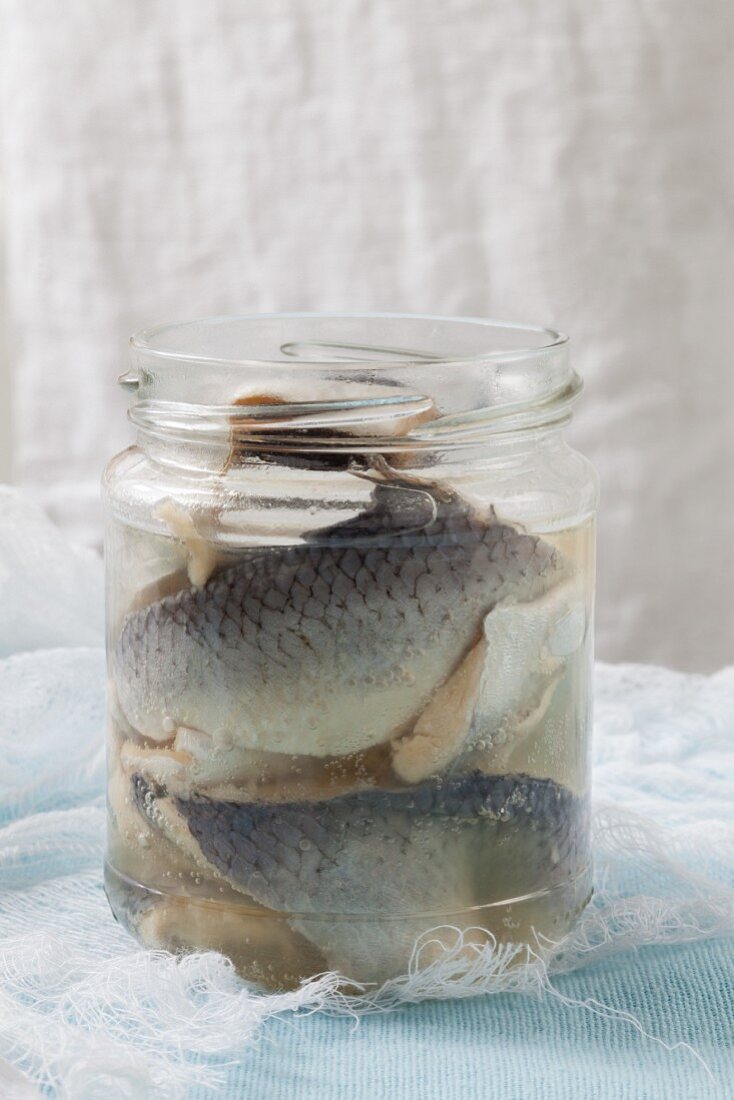 An open jar of pickled herring fillets