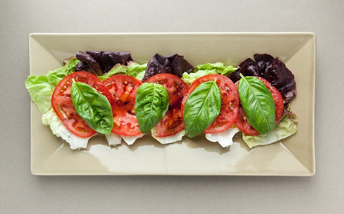 Batavia lettuce leaves topped with tomato and basil