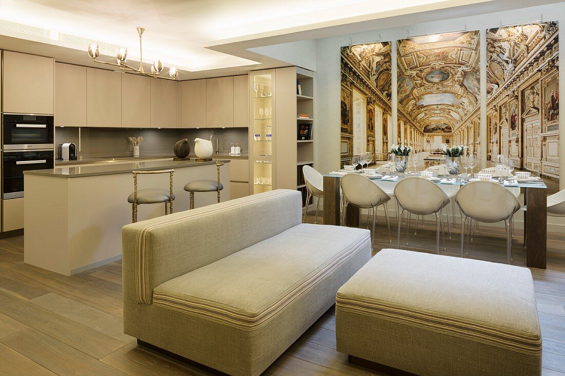 Open-plan living area in elegant beige interior with trompe l'oeil panels behind set dining table