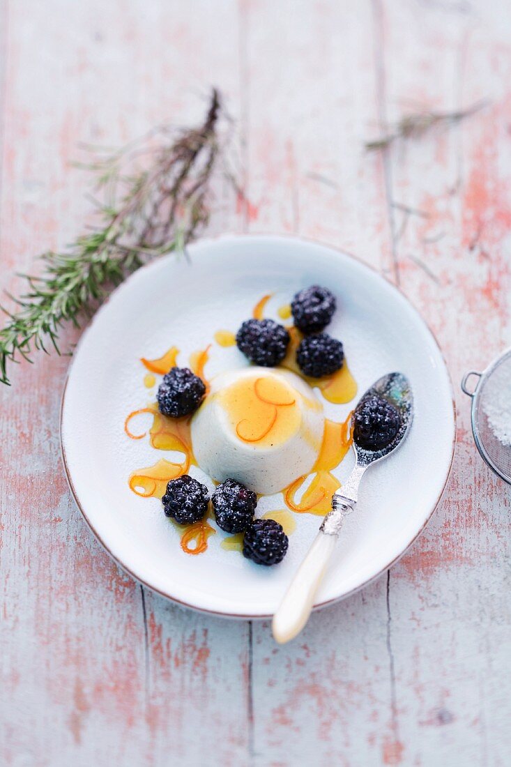 Rosemarie panna cotta with orange sauce and blackberries