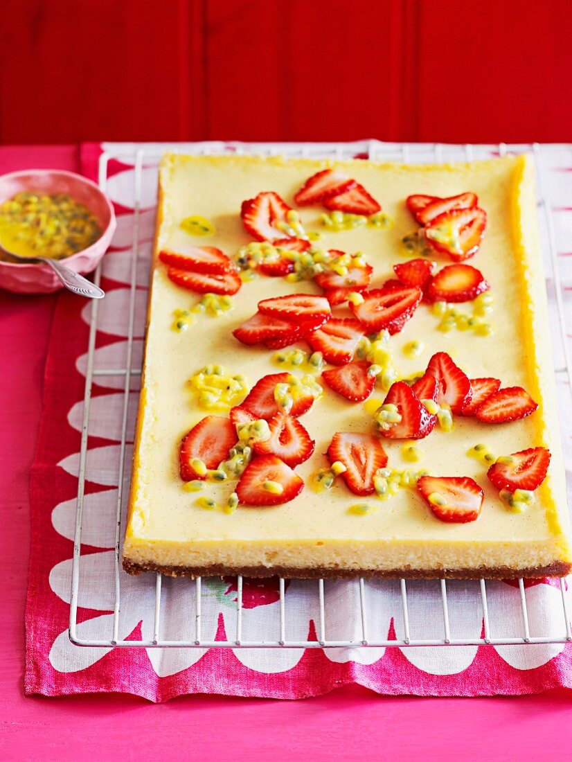 Sour cream cheesecake with strawberries and passion fruit on a baking tray