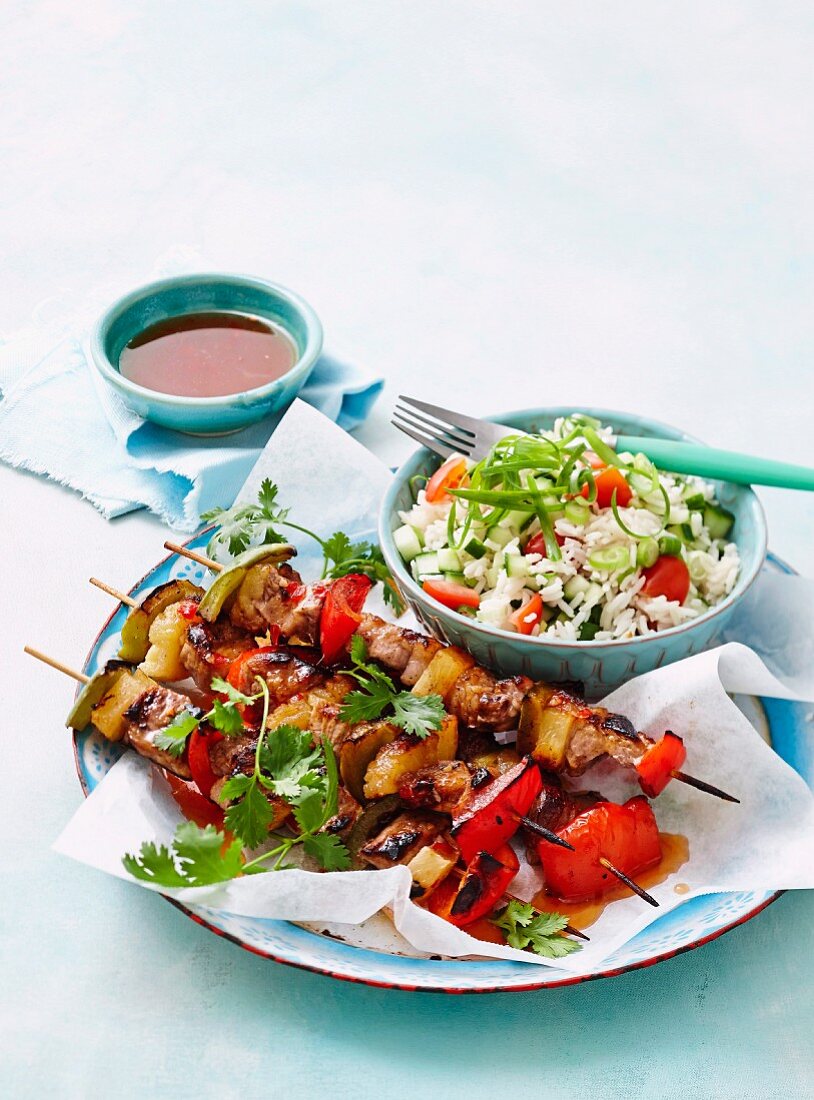 Sweet and sour pork skewers with rice salad