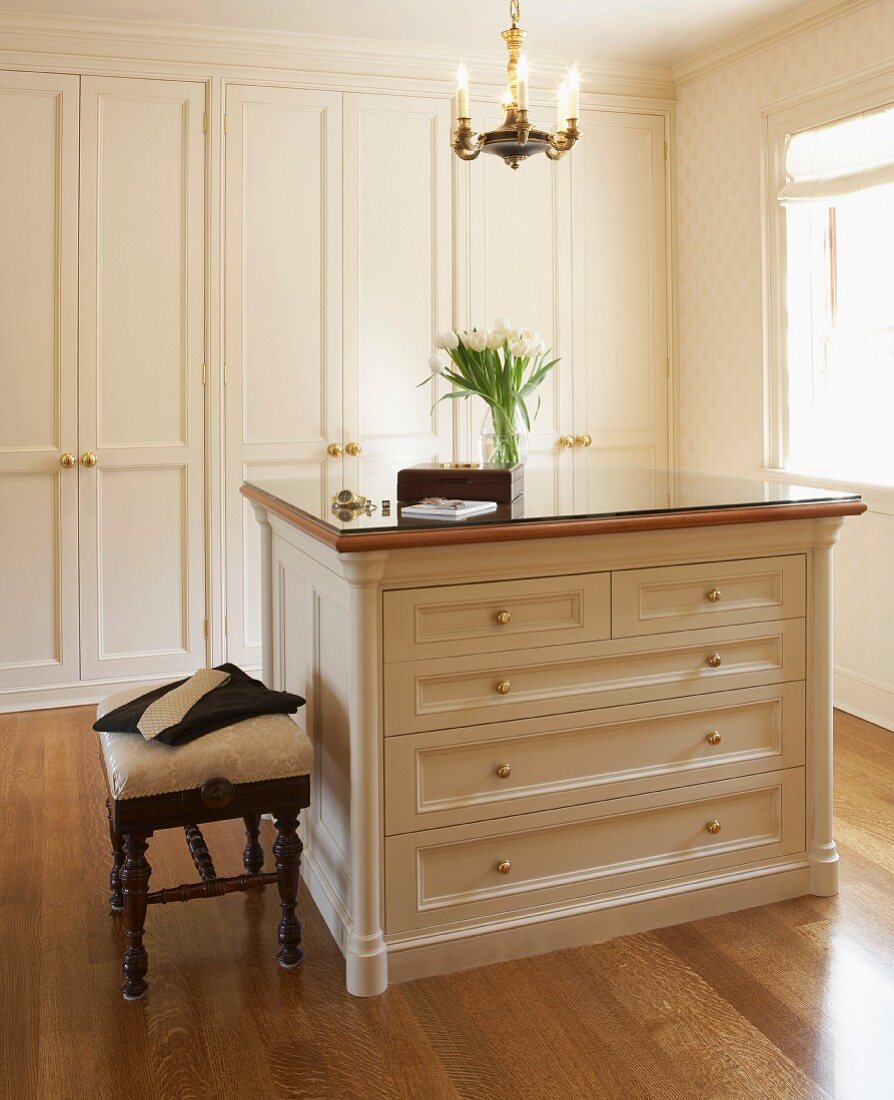 Elegant dressing area with fitted wardrobes, chest of drawers and exotic wood parquet floor